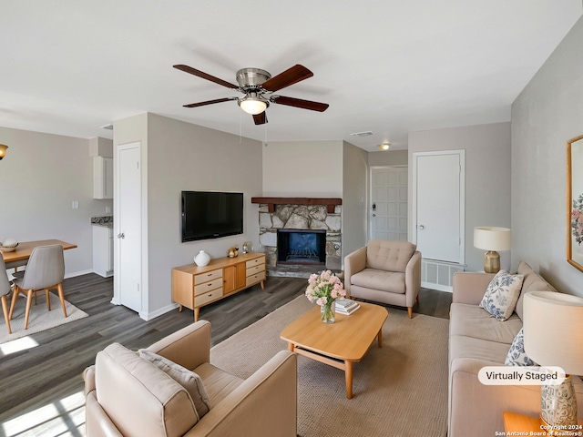 living room with ceiling fan, a fireplace, and dark hardwood / wood-style floors