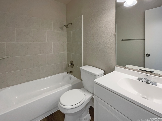 full bathroom featuring vanity, tiled shower / bath combo, and toilet