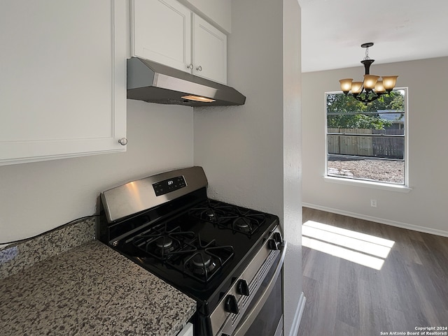 kitchen with stone countertops, stainless steel gas stove, white cabinetry, a chandelier, and dark hardwood / wood-style floors