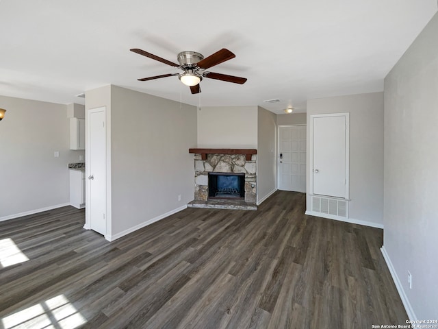 unfurnished living room with ceiling fan, a fireplace, and dark hardwood / wood-style flooring