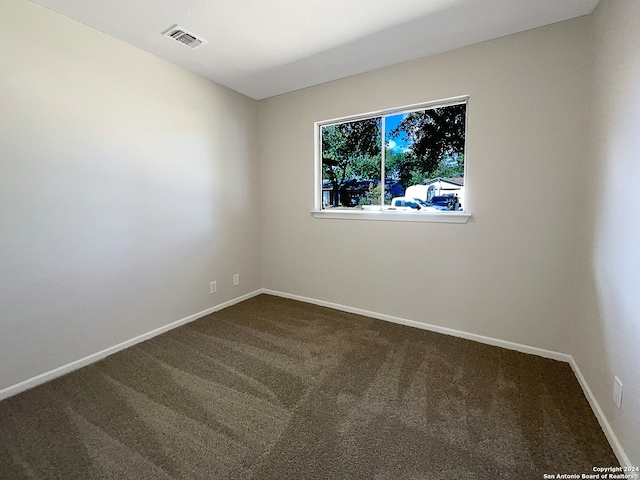 unfurnished room with dark carpet