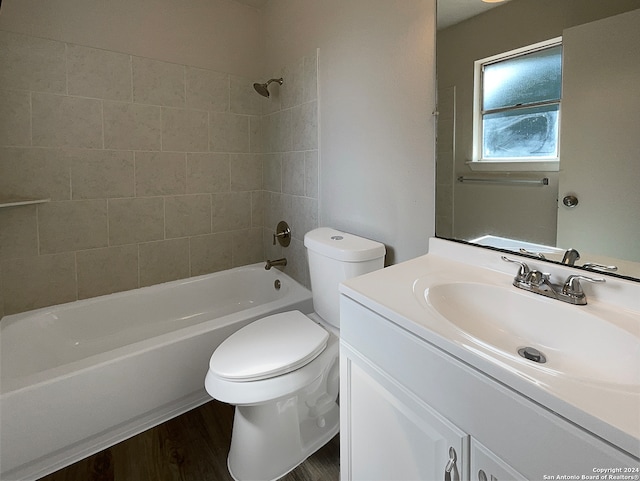 full bathroom with toilet, tiled shower / bath, vanity, and wood-type flooring