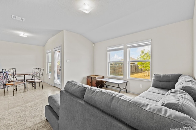 tiled living room with lofted ceiling and a wealth of natural light