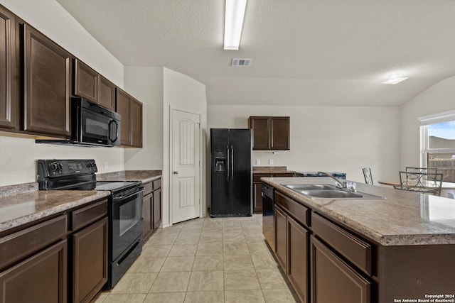 kitchen with a textured ceiling, a kitchen island with sink, black appliances, dark brown cabinetry, and sink