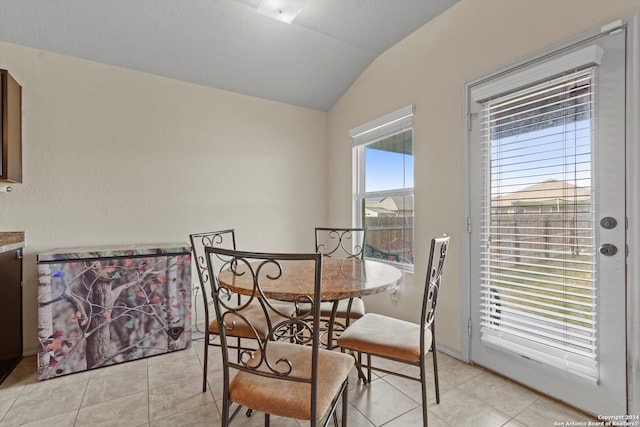 dining space featuring vaulted ceiling and light tile patterned floors