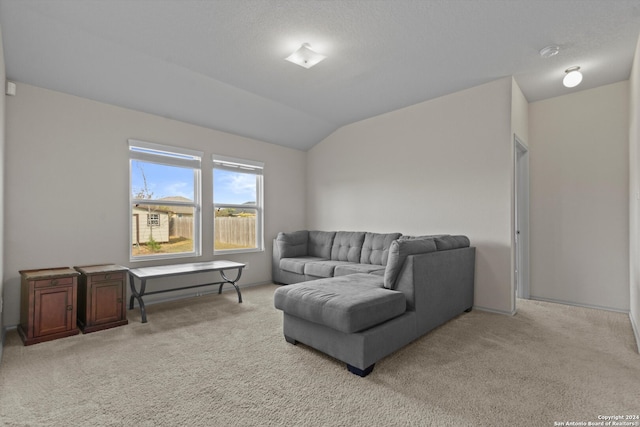 carpeted living room featuring a textured ceiling and lofted ceiling