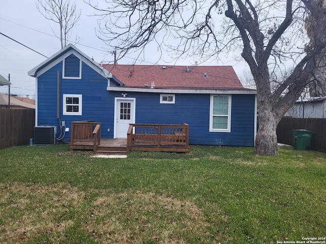 back of property featuring a deck, a lawn, and central AC