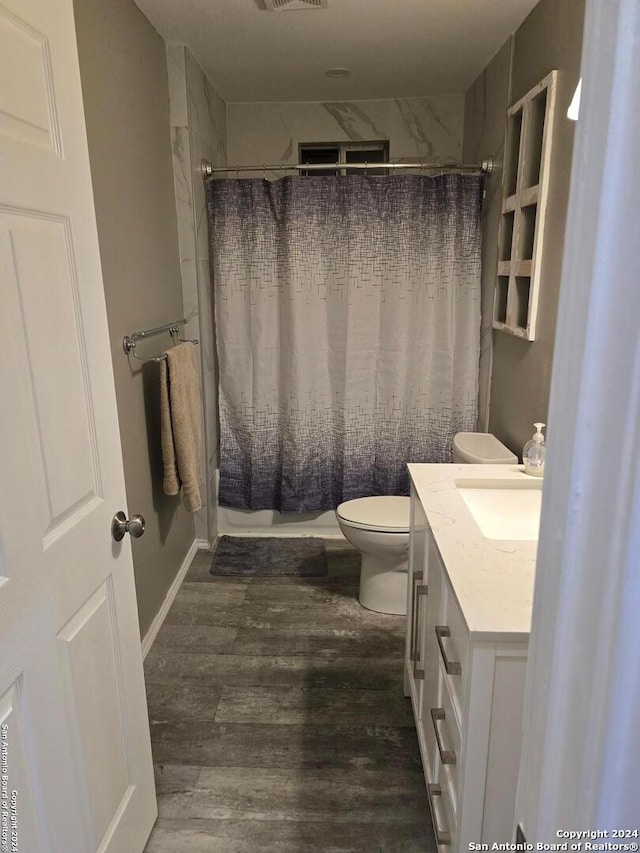 full bathroom featuring toilet, hardwood / wood-style flooring, vanity, and shower / bath combo with shower curtain