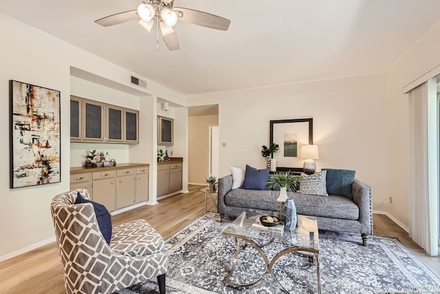 living room with light wood-type flooring and ceiling fan