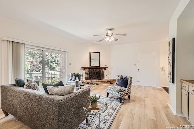 living room with light hardwood / wood-style floors, a fireplace, and ceiling fan