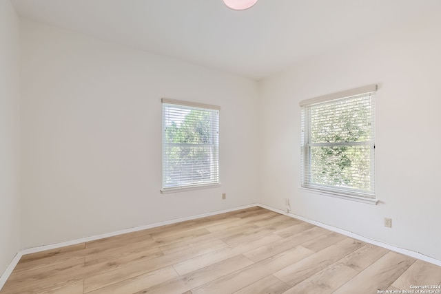 spare room with light hardwood / wood-style floors and plenty of natural light