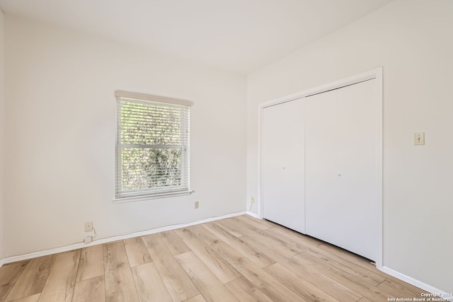 unfurnished bedroom featuring a closet and light wood-type flooring