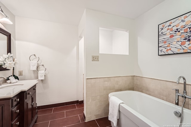 bathroom featuring vanity, tile patterned floors, and a washtub