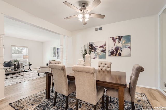 dining space with light hardwood / wood-style flooring, ornate columns, and ceiling fan