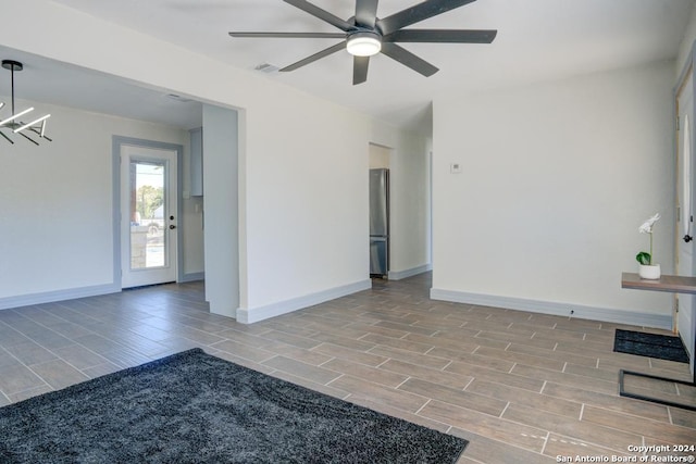 unfurnished room with ceiling fan with notable chandelier