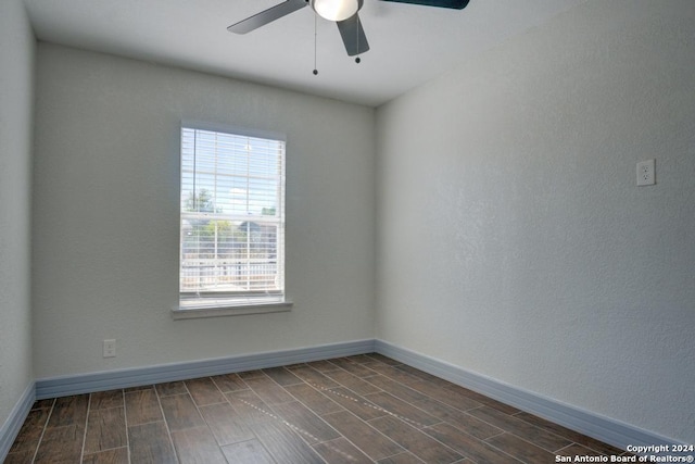 spare room with dark wood-type flooring and ceiling fan