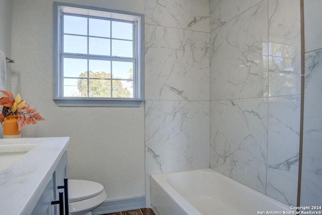 full bathroom with tiled shower / bath, vanity, hardwood / wood-style flooring, and toilet