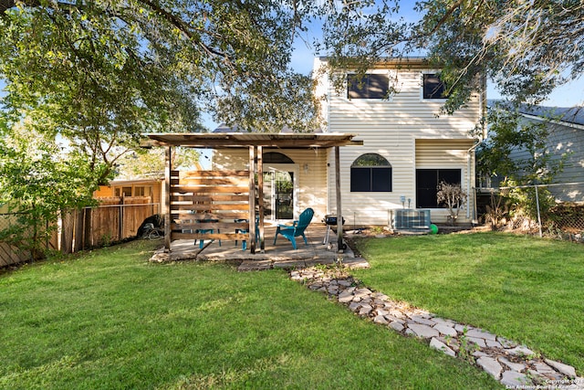 rear view of house with a patio, central AC unit, and a yard