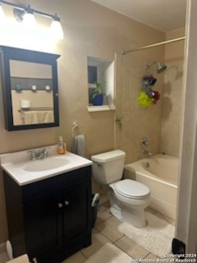 full bathroom featuring vanity, tile patterned flooring, toilet, and tiled shower / bath