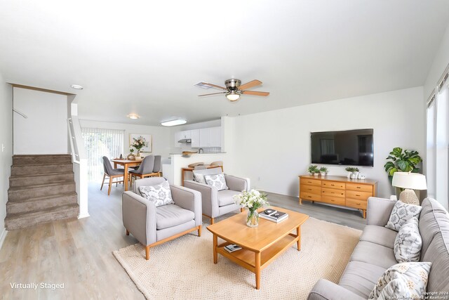 living room featuring ceiling fan, stairs, and light wood-style flooring