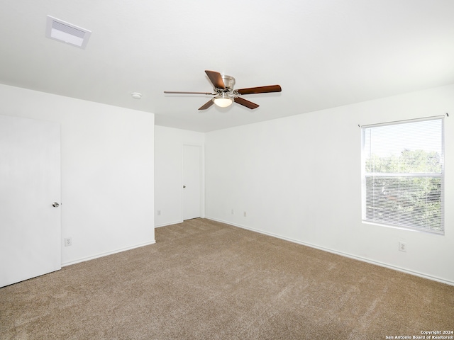 empty room featuring ceiling fan and light carpet