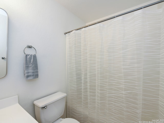 bathroom with a shower with curtain and toilet