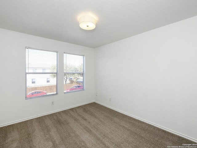 empty room featuring carpet and baseboards