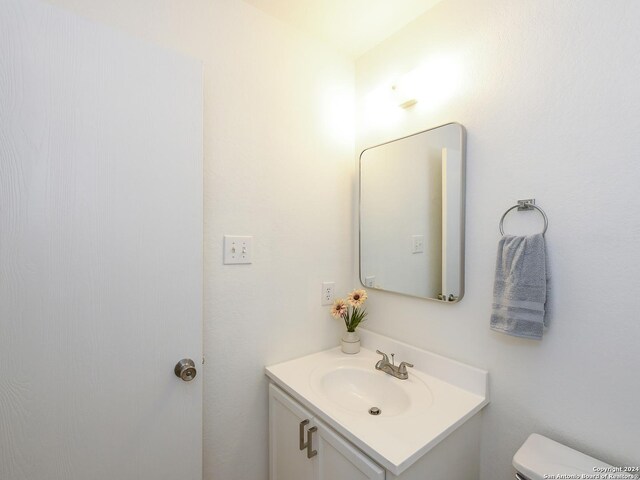 half bathroom with vanity and toilet