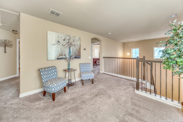 living area with a textured ceiling and carpet floors