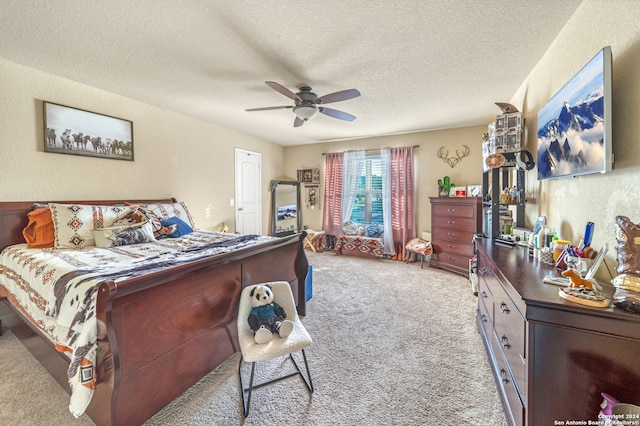 carpeted bedroom featuring ceiling fan and a textured ceiling