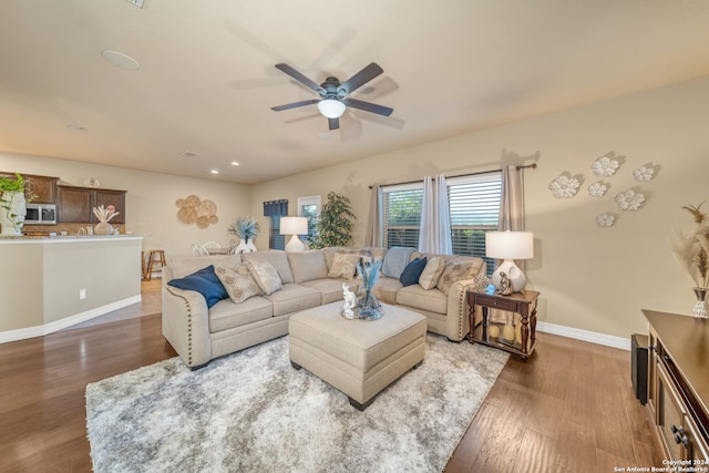 living room with dark wood-type flooring and ceiling fan