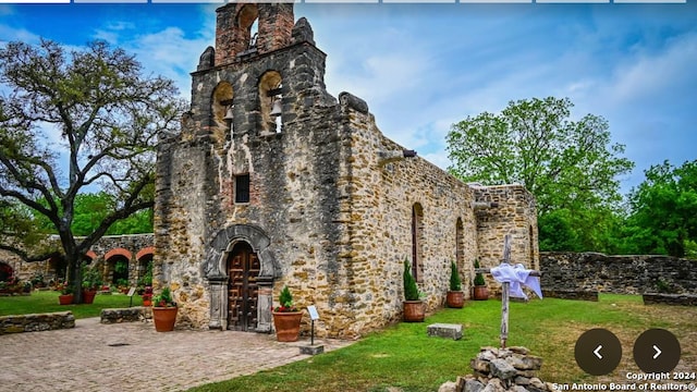 9446 Espada, San Antonio, TX 78214 - view of side of property with a chimney, a yard, and stone siding