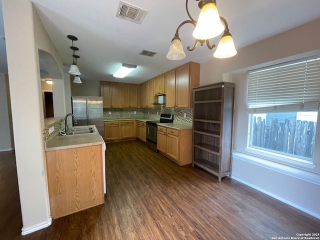 kitchen with decorative backsplash, dark wood-type flooring, sink, black appliances, and pendant lighting