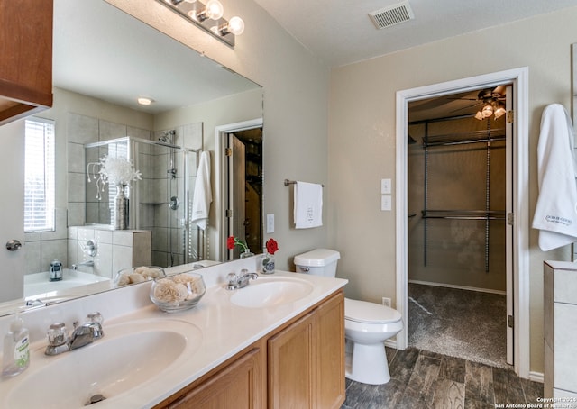 bathroom featuring a shower with door, toilet, ceiling fan, and vanity