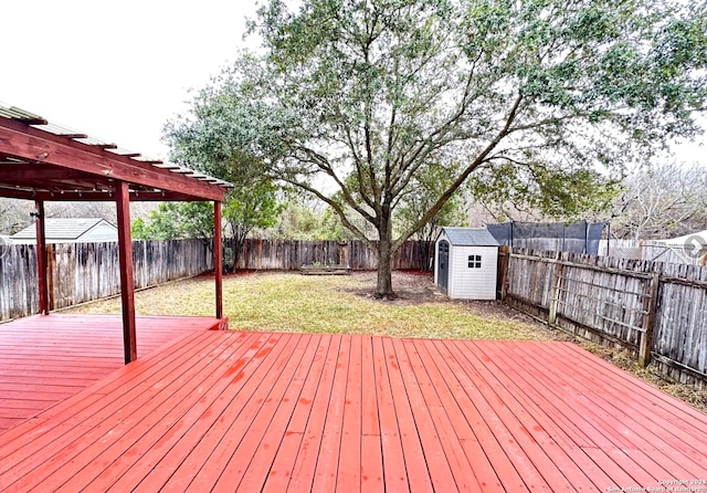 wooden deck with a yard and a storage unit