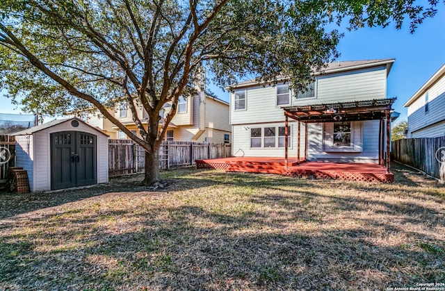 rear view of property with a storage unit, a deck, a yard, and a pergola