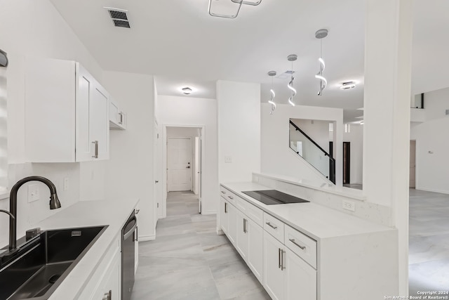 kitchen featuring sink, black electric cooktop, decorative light fixtures, stainless steel dishwasher, and white cabinets