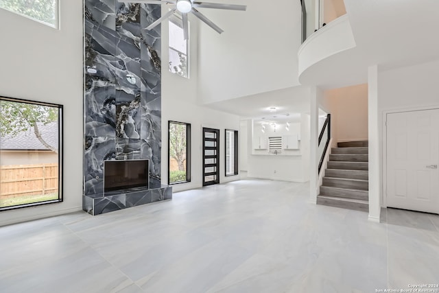 living room with a high ceiling, a wealth of natural light, and a fireplace