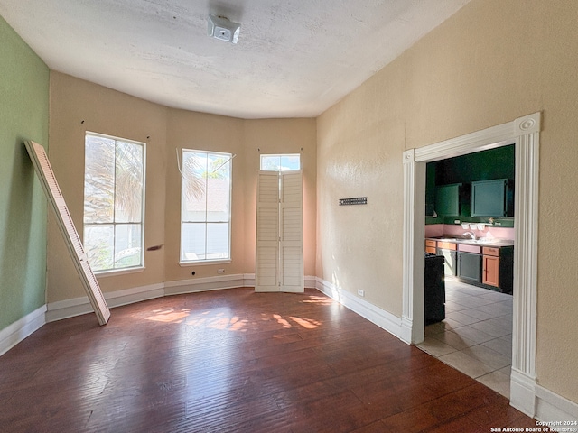 unfurnished room with sink, light hardwood / wood-style flooring, and a textured ceiling