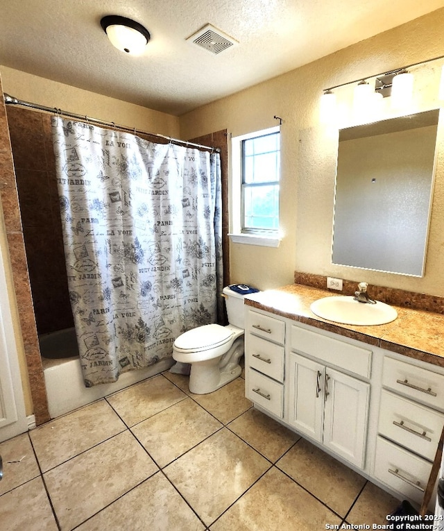 full bathroom with a textured ceiling, toilet, shower / bath combo, vanity, and tile patterned flooring