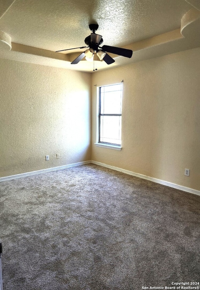 carpeted empty room featuring ceiling fan and a textured ceiling