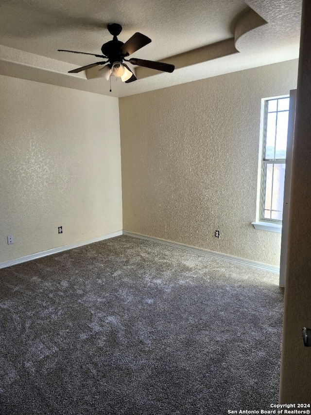 spare room with a textured ceiling, carpet flooring, and ceiling fan