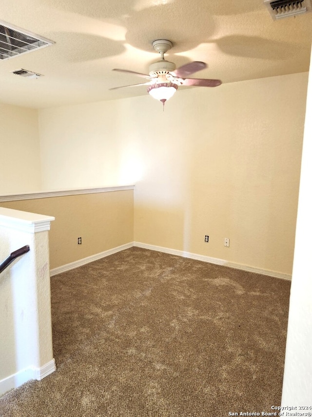 carpeted empty room featuring a textured ceiling and ceiling fan