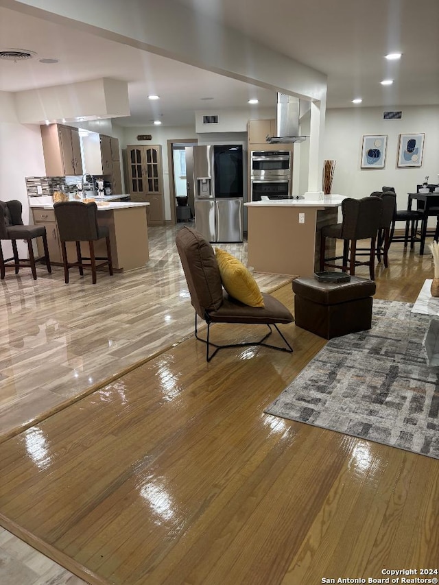 living area with recessed lighting, visible vents, and light wood-style flooring
