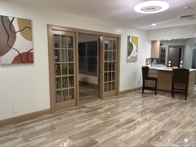 interior space with baseboards, visible vents, and french doors
