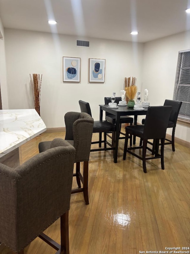 dining space with recessed lighting, visible vents, hardwood / wood-style floors, and baseboards