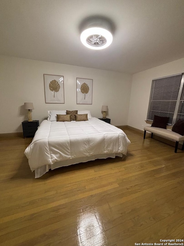 bedroom with wood finished floors and baseboards