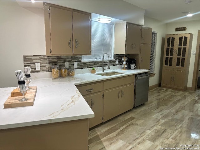 kitchen featuring sink, light wood-type flooring, stainless steel dishwasher, light stone counters, and tasteful backsplash