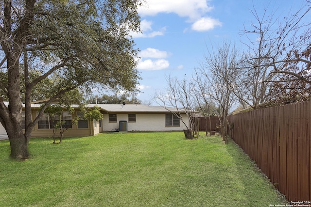 back of house featuring a yard and fence