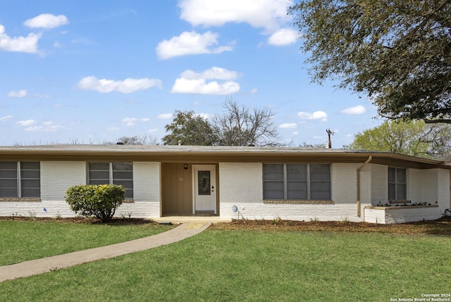 ranch-style home featuring a front yard and brick siding